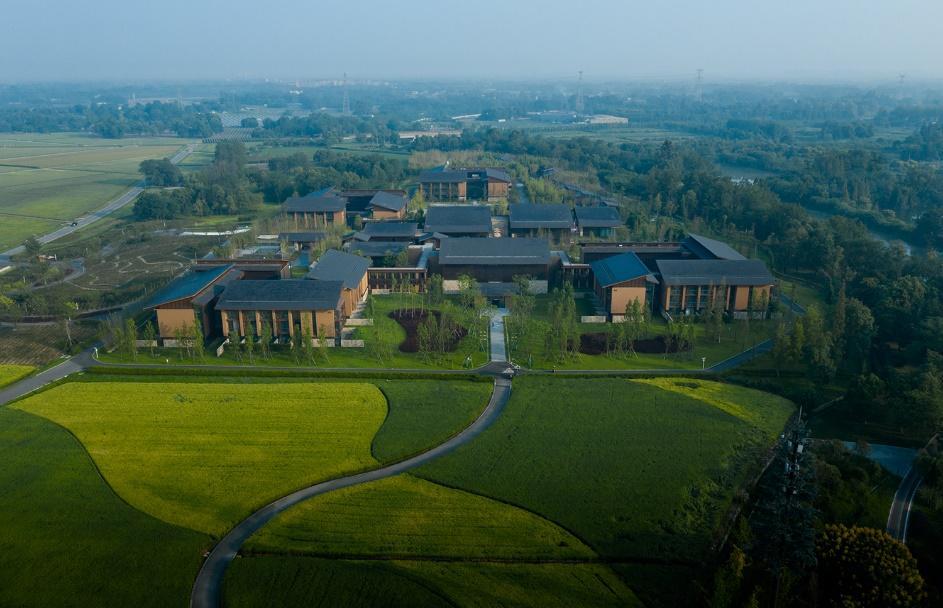 A group of buildings in a green field AI-generated content may be incorrect.