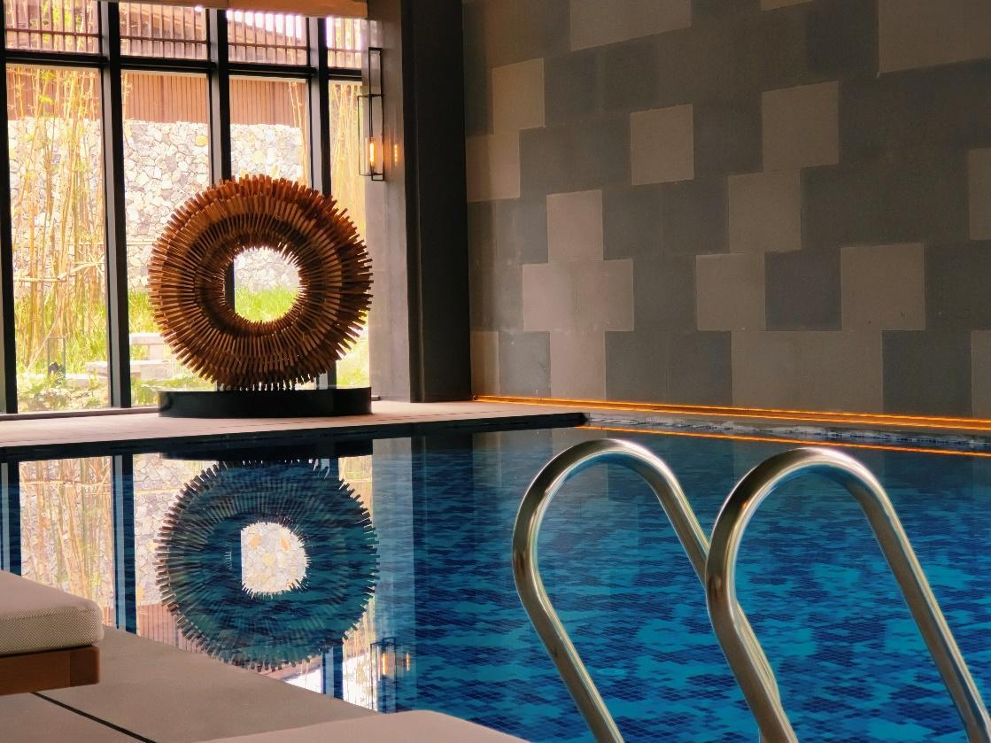 A swimming pool with a sculpture in the middle AI-generated content may be incorrect.